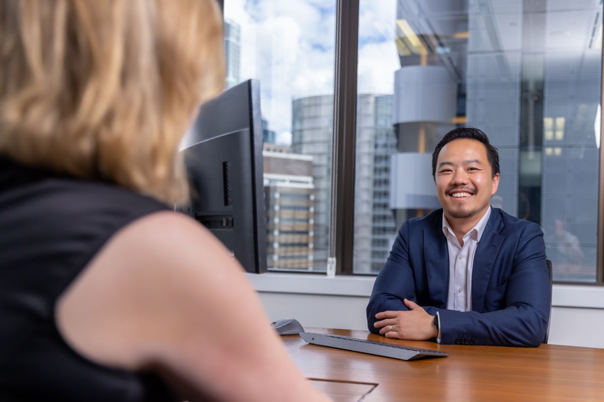 Multi Asset Portfolio Manager Ainsley Lee sitting with a client with Sydney city in the background