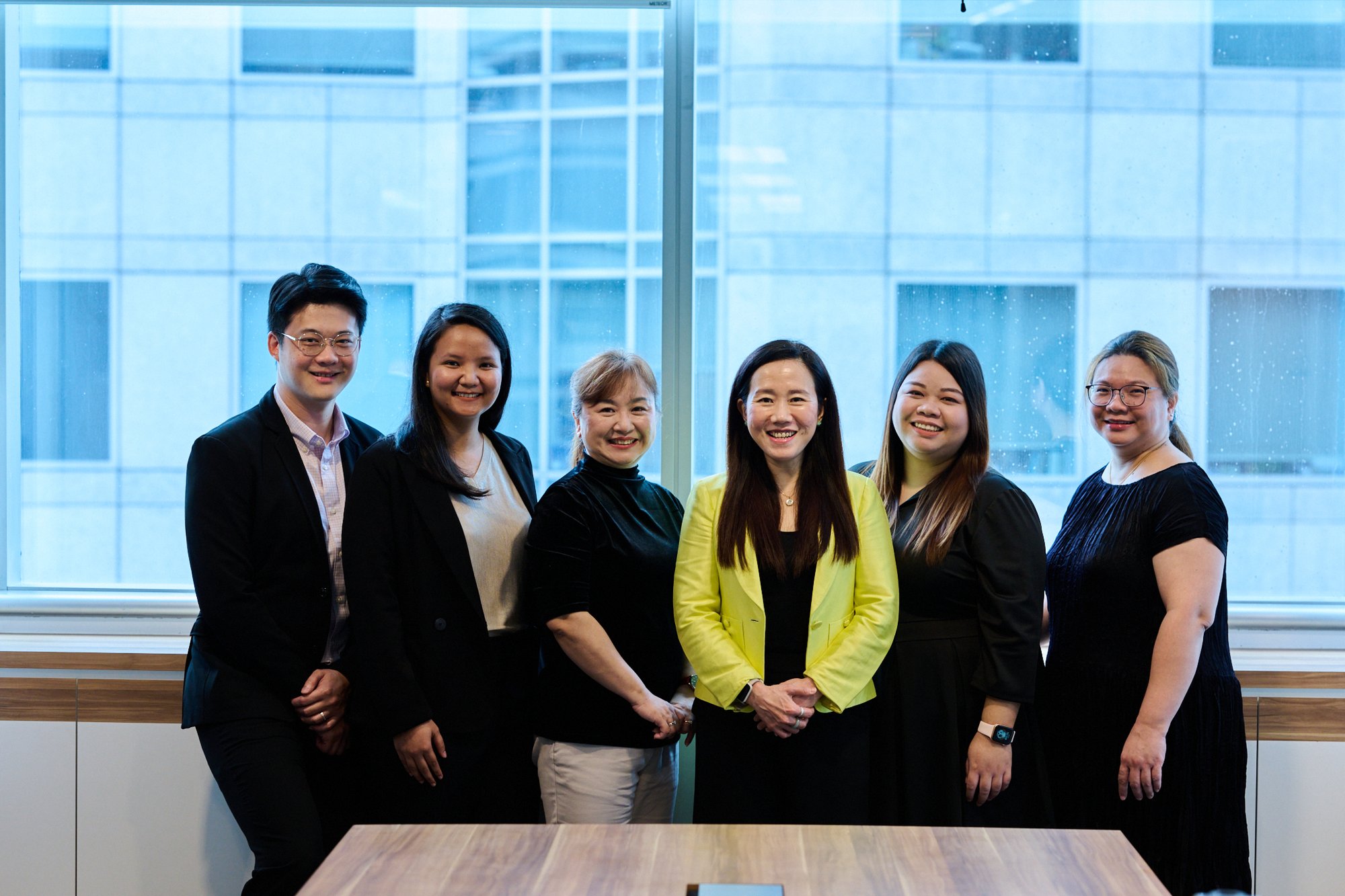 Aura Partners Singapore accounting team standing together against a city scape