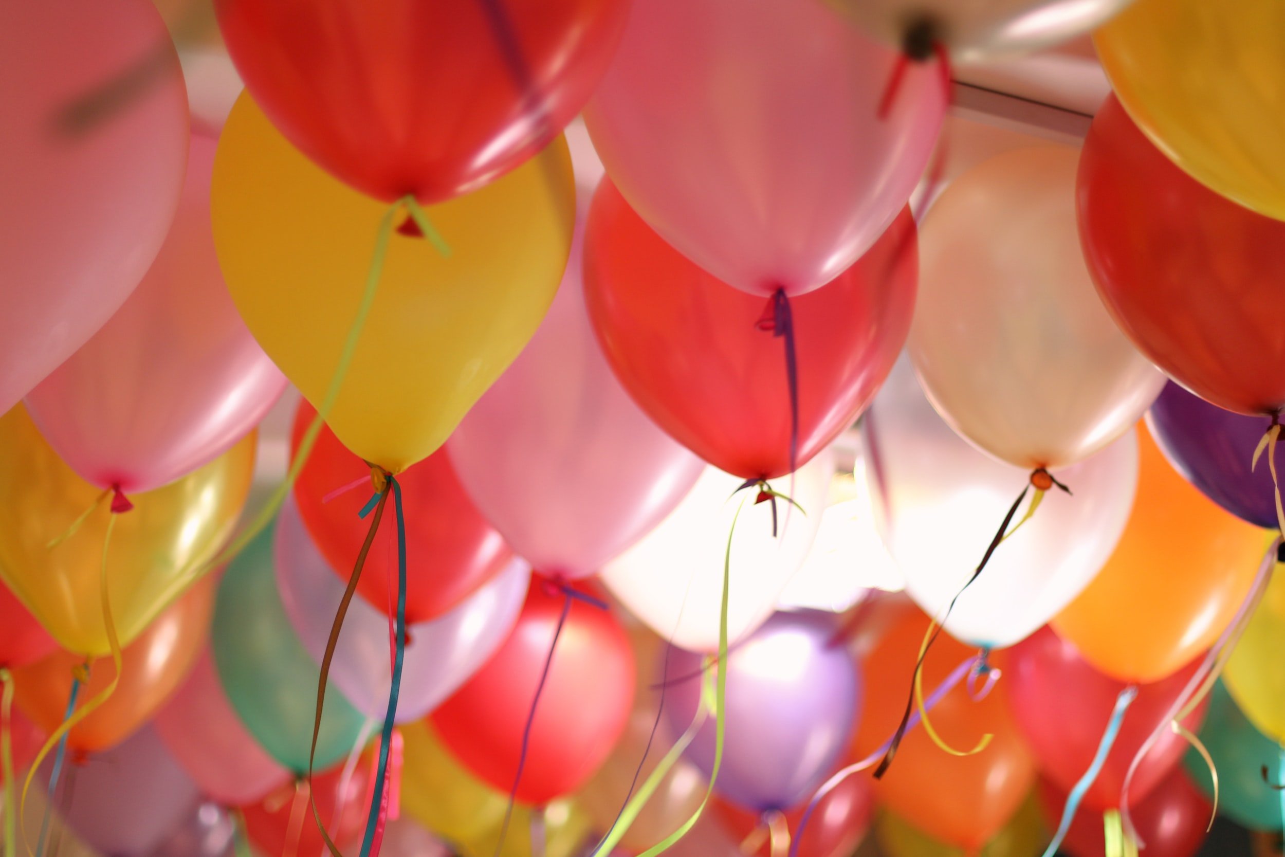 Yellow, read, and pink balloons hitting the ceiling
